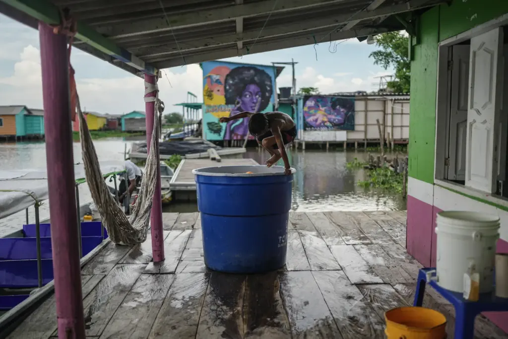 A child jumps into a container of water Thursday, April...