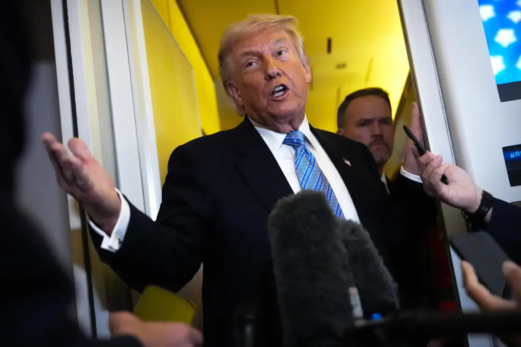 Donald Trump speaks to reporters aboard Air Force One