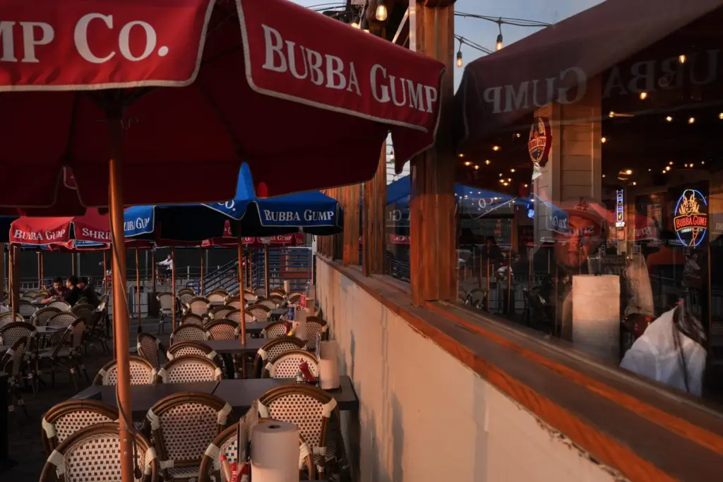 A diner looks out a restaurant window at sunset in...
