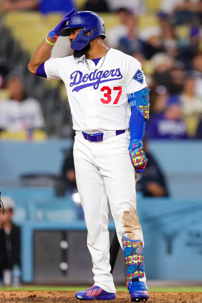 The Dodgers’ Teoscar Hernandez challenges a pitch by tapping his...