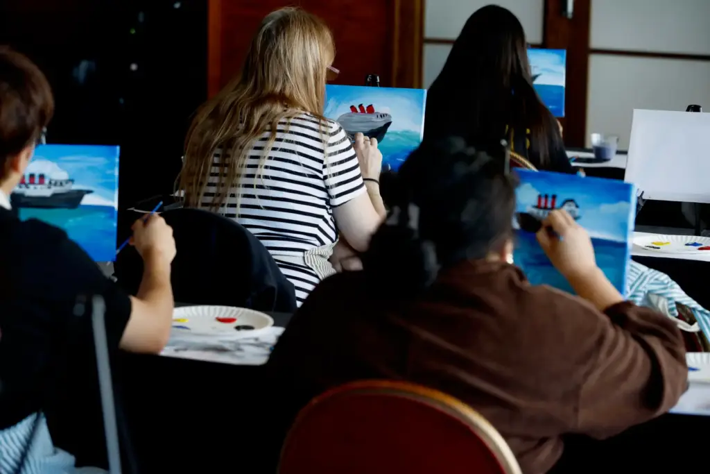 Attendees take part in a âPaint the Queenâ art class...