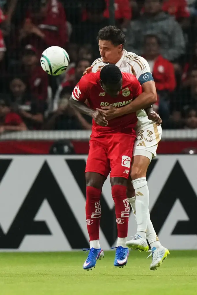 LAFC’s Aaron Long, back, challenges Toluca FC’s Helinho as he...