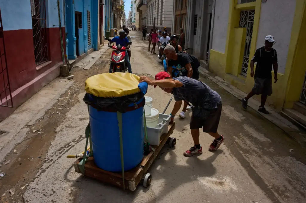 People transport containers of water in Havana, Wednesday, May 27,...