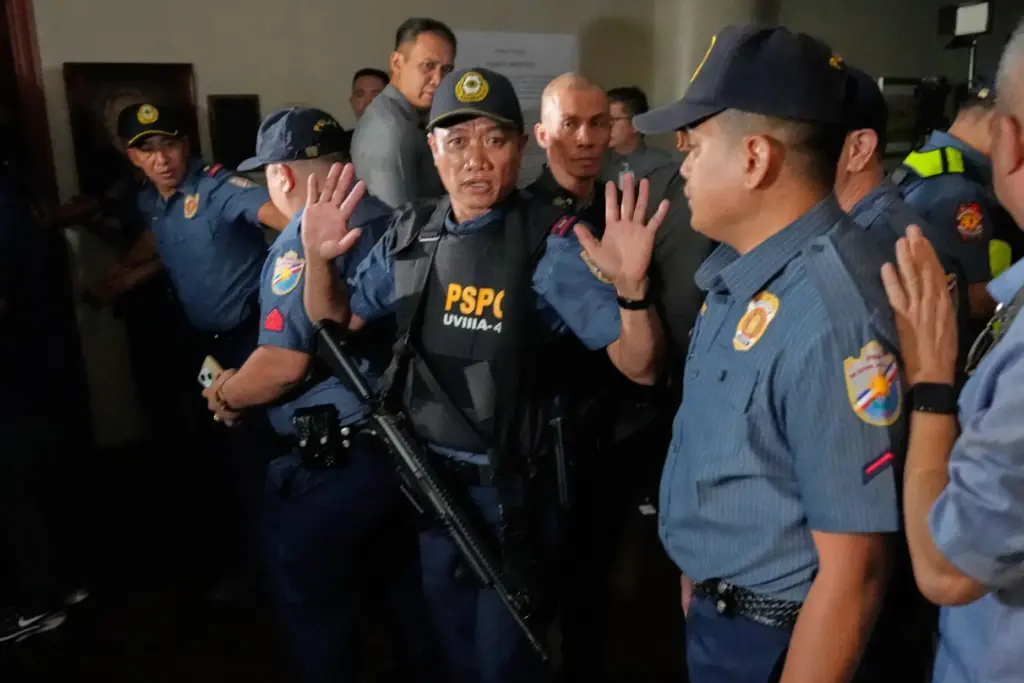 Police clear the area of the media as gunshots were...