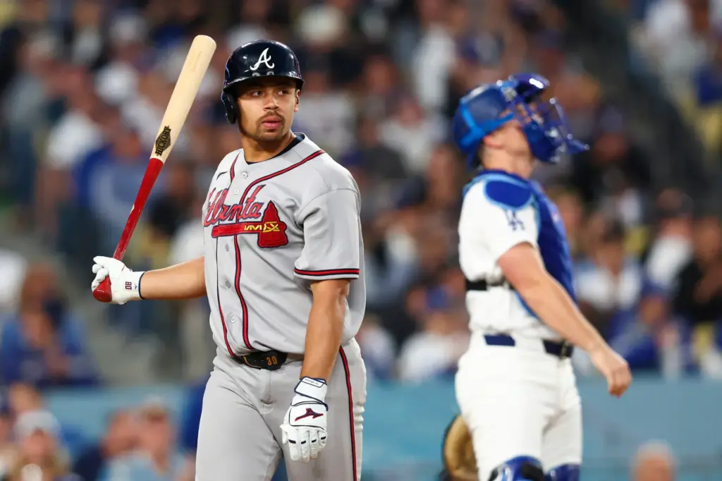 The Atlanta Braves’ Drake Baldwin, left, looks on after striking...