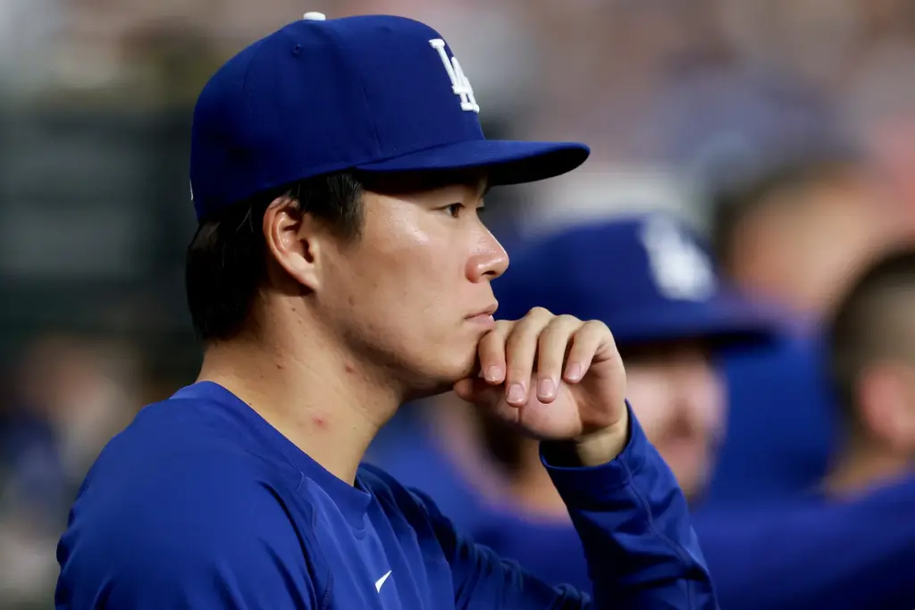 Dodgers starting pitcher Yoshinobu Yamamoto looks on from the dugout...