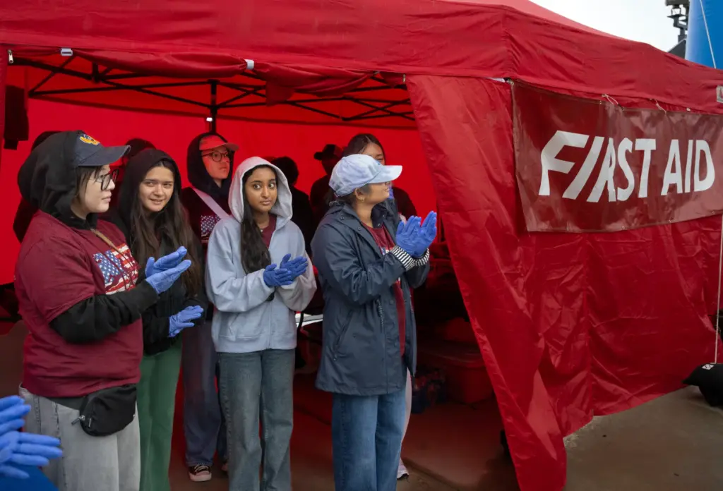 First aid volunteers take shelter in a tent during a...