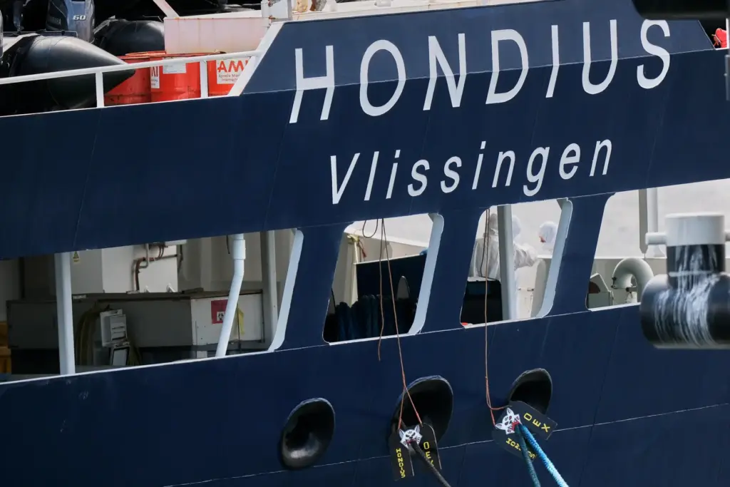 A crew in protective gear works on the MV Hondius cruise ship