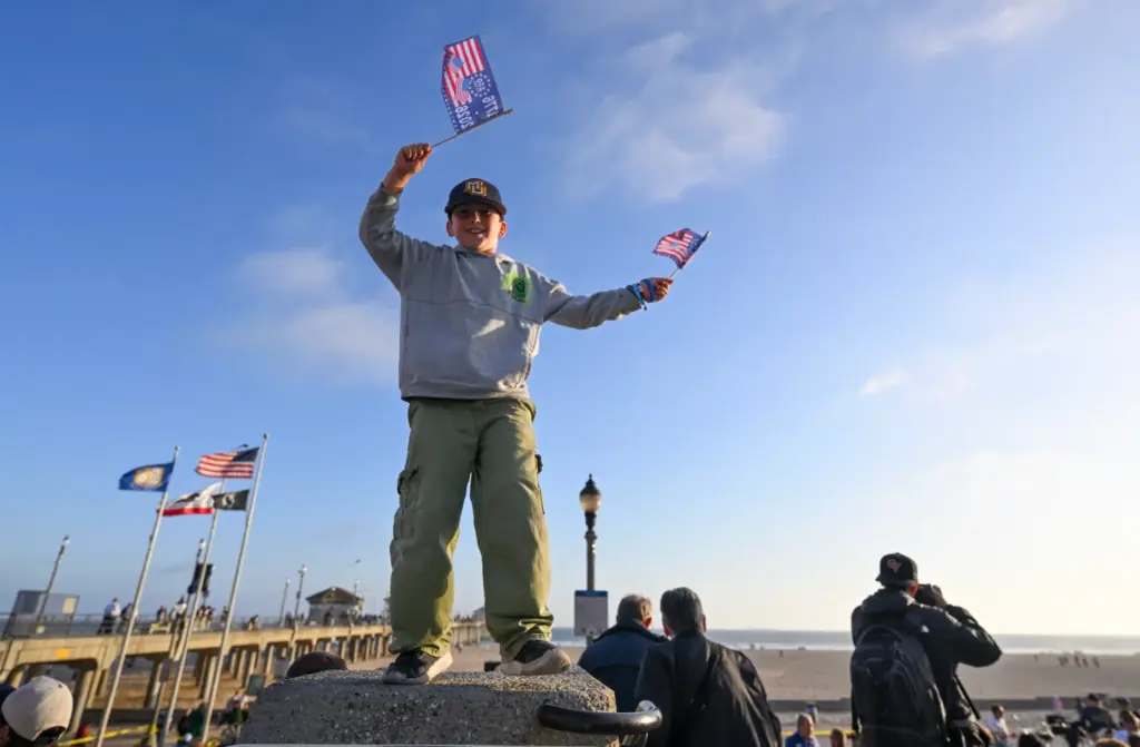 Colston Valenzuela, 8, dances with American semiquincentennial flags during a...