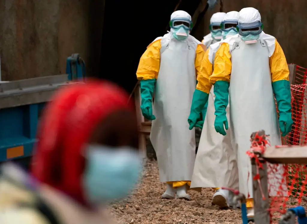 Health workers dressed in protective gear begin their shift at an Ebola treatment center