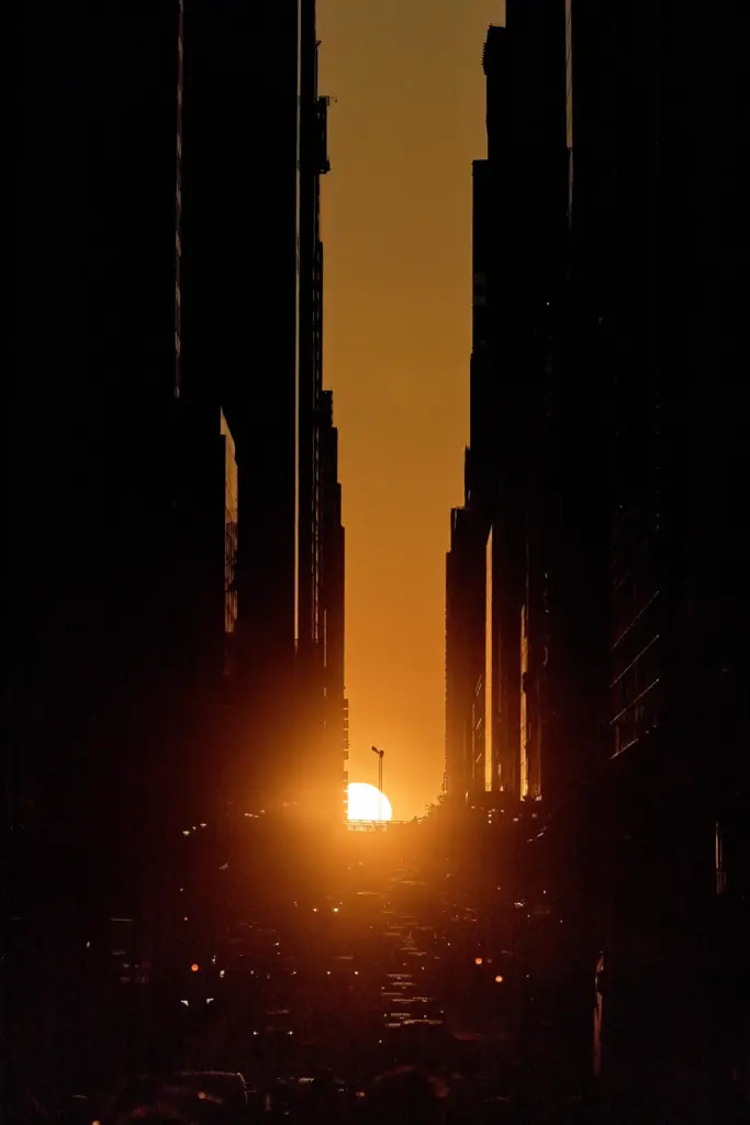 The setting sun is framed between buildings during Manhattanhenge.