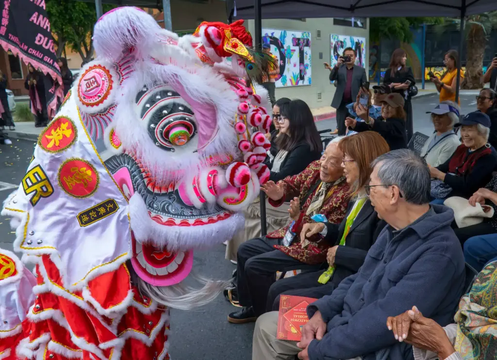 A lion dancer interacts with those attending the Chinatown Memorial...