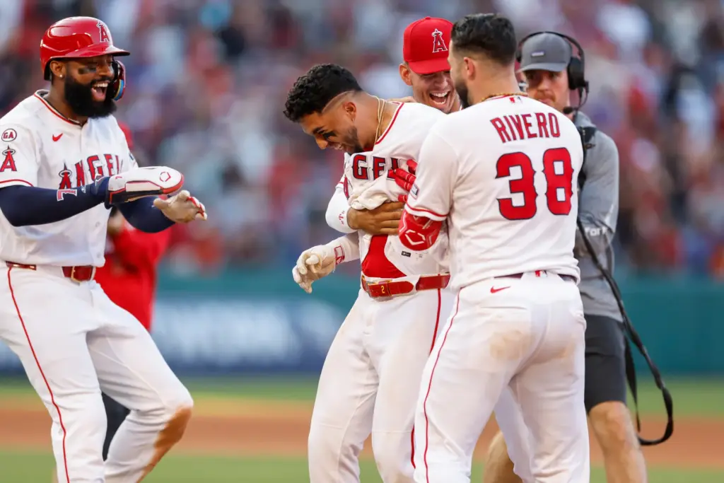 The Angels’ Oswald Peraza, center, is greeted by teammates after...