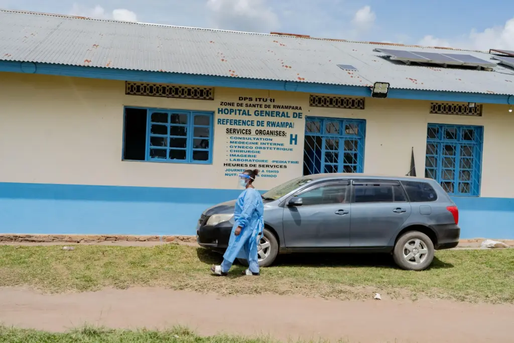 A health worker wearing protective gear walks outside the a...