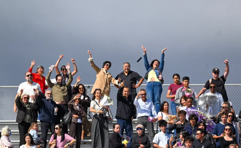 Family and friends cheer for graduates during the commencement ceremony...