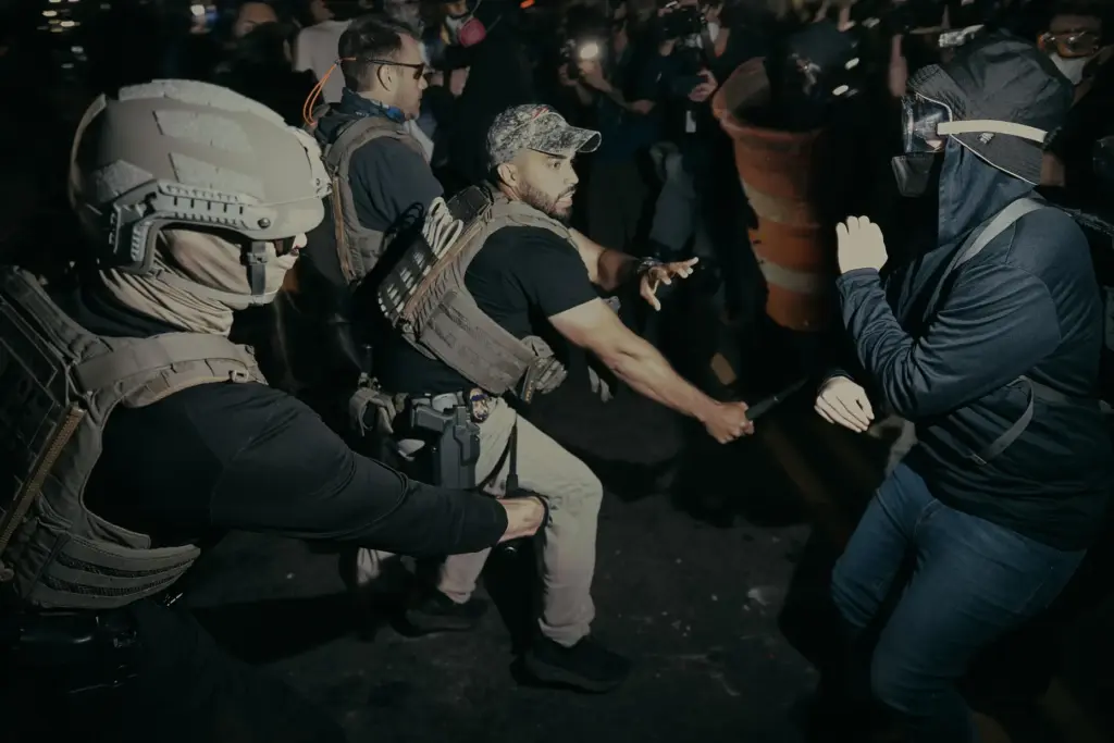 ICE agents use their baton as they clash with protesters...