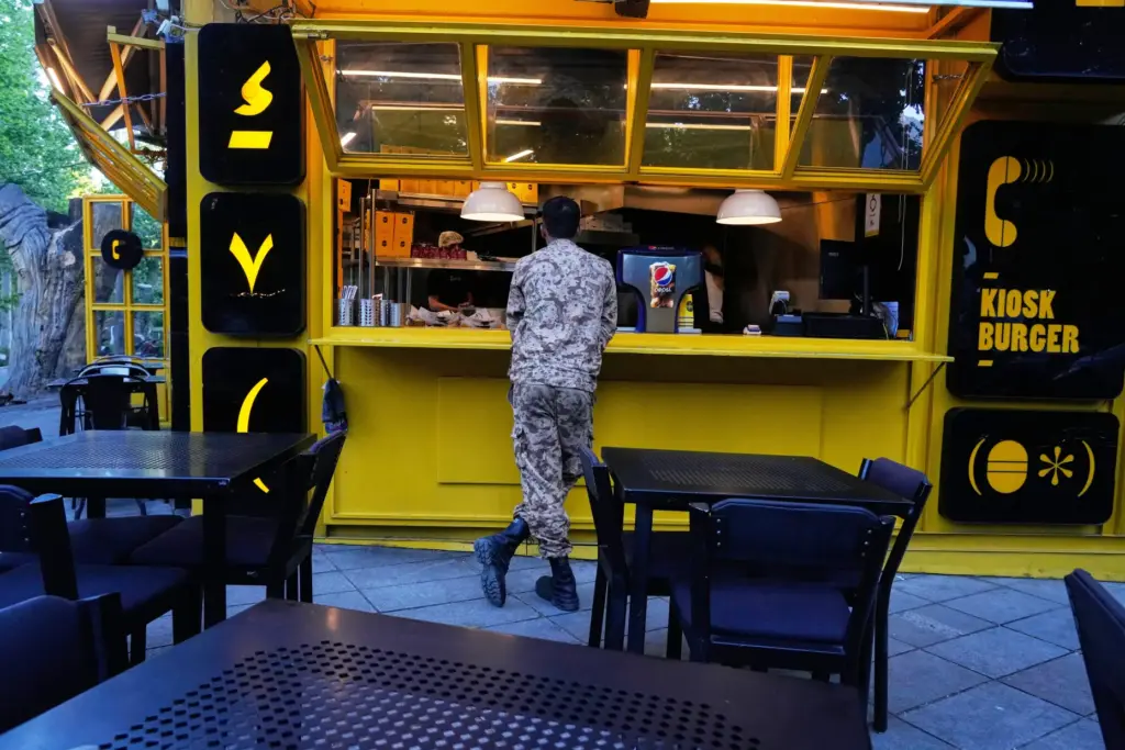 A Revolutionary Guard soldier stands at the counter of a...
