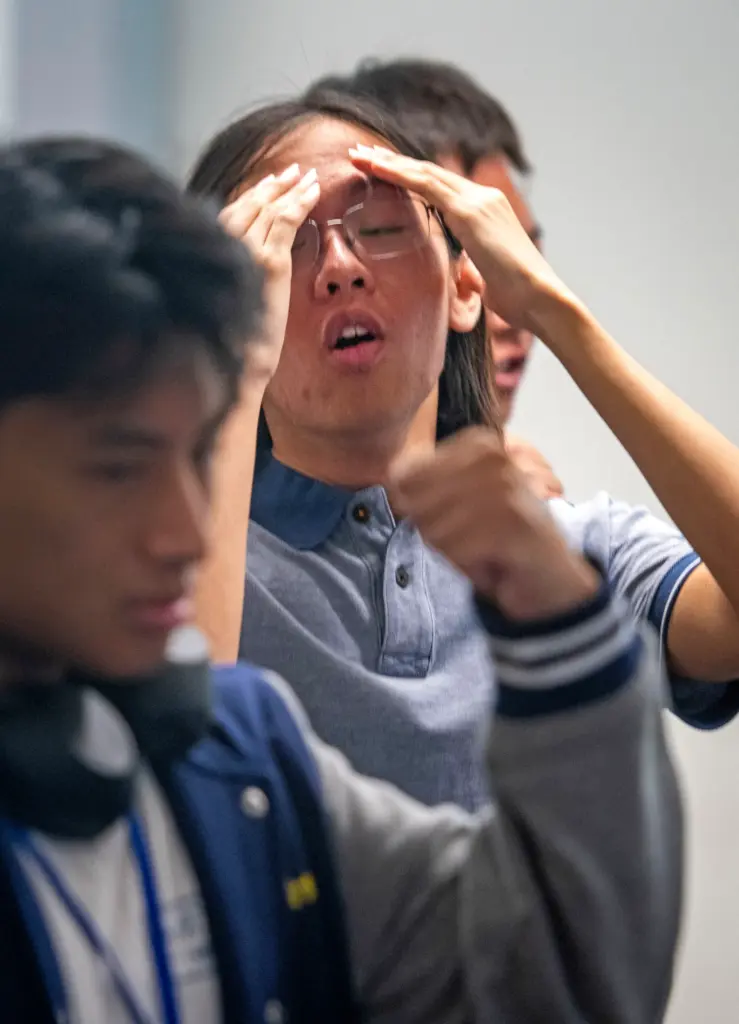Troy High games coach, Jonathon Hsiao, center, shows the stress...