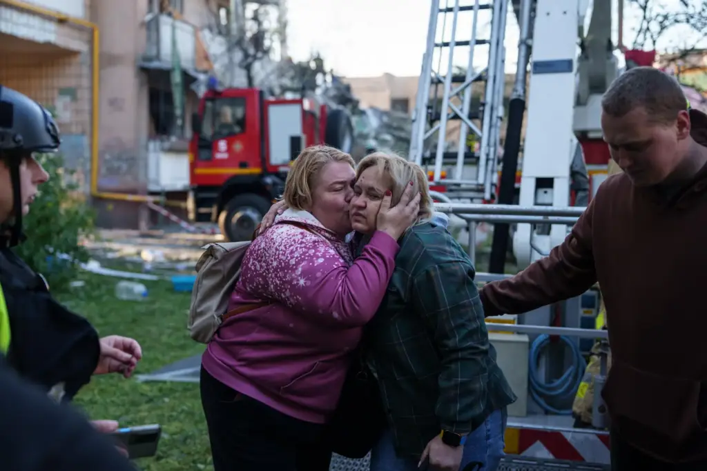 A woman kisses her relative evacuated from a house heavily damaged after a Russian strike.