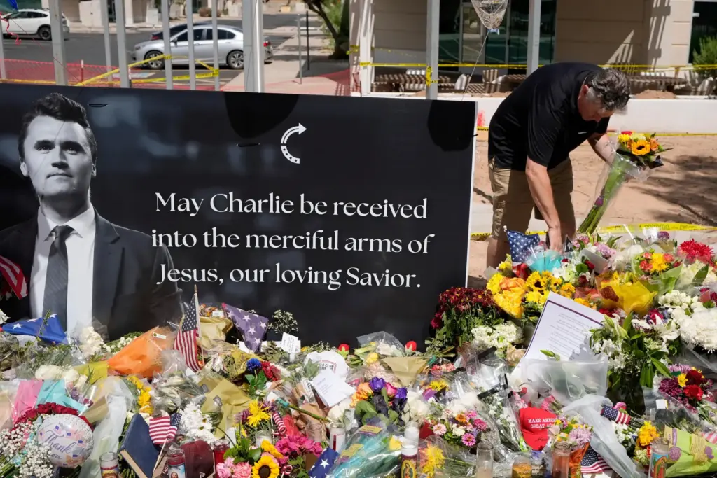 A well-wisher places flowers at a makeshift memorial set up for Charlie Kirk.