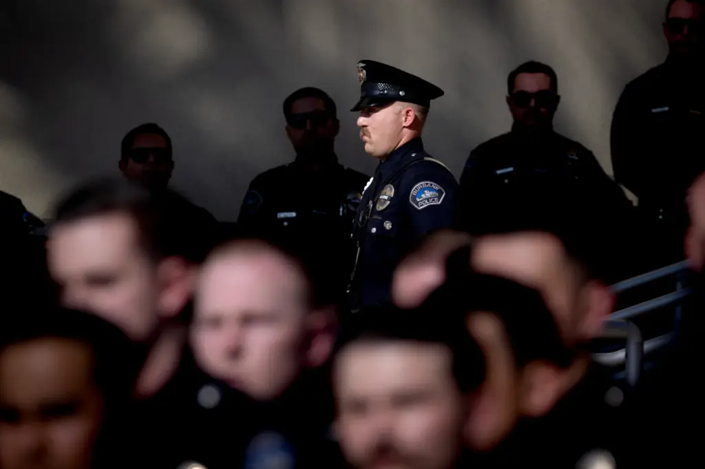 Members of the Burbank Police Department listen to speakers during...