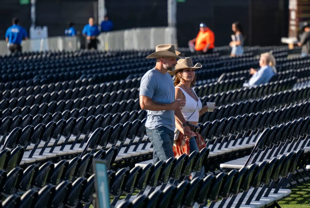Fans of Billy Currington look for the seats as they...