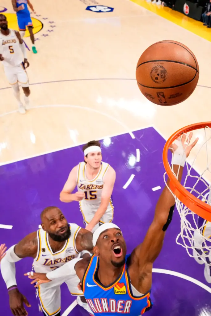 Oklahoma City Thunder guard Shai Gilgeous-Alexander, right, shoots as Lakers...