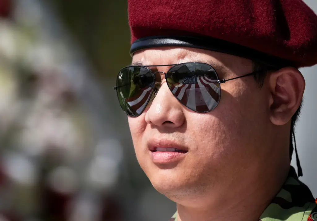 The American flag is reflected in a manâs sunglasses during...