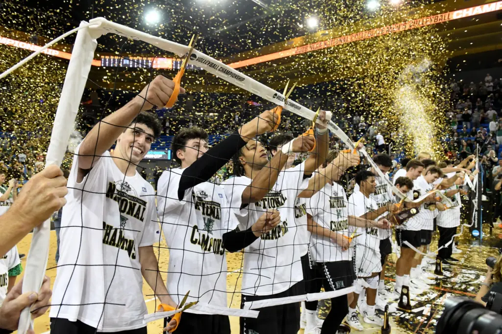 Hawaii players cut down the net as they celebrate after...