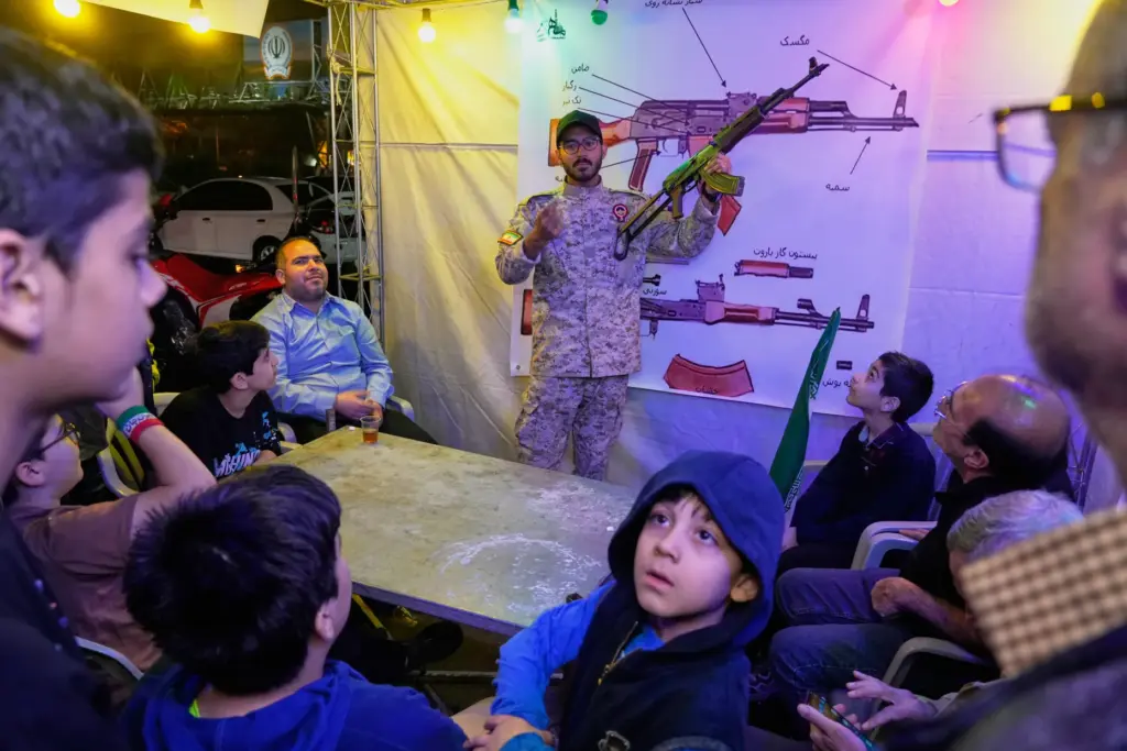 A member of the Revolutionary Guard's Basij force demonstrates how to handle a Kalashnikov-style assault rifle.