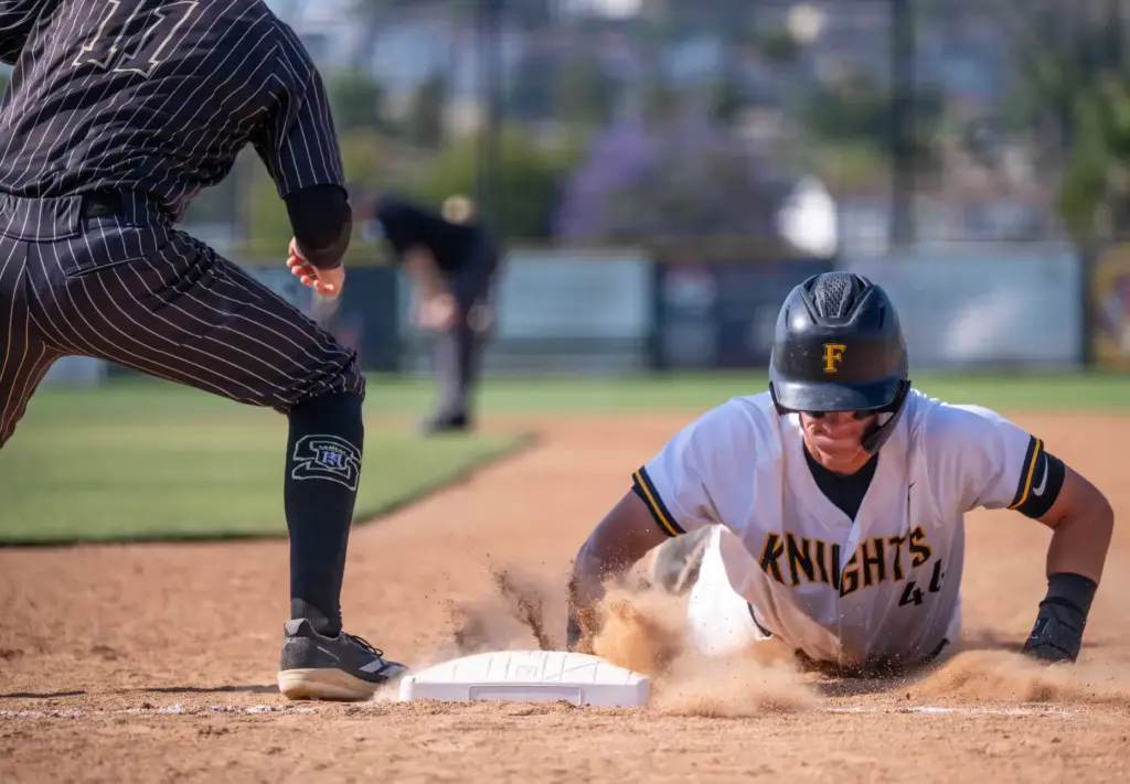 Foothill infielder Jaxon Foshay dives safely back to first base...