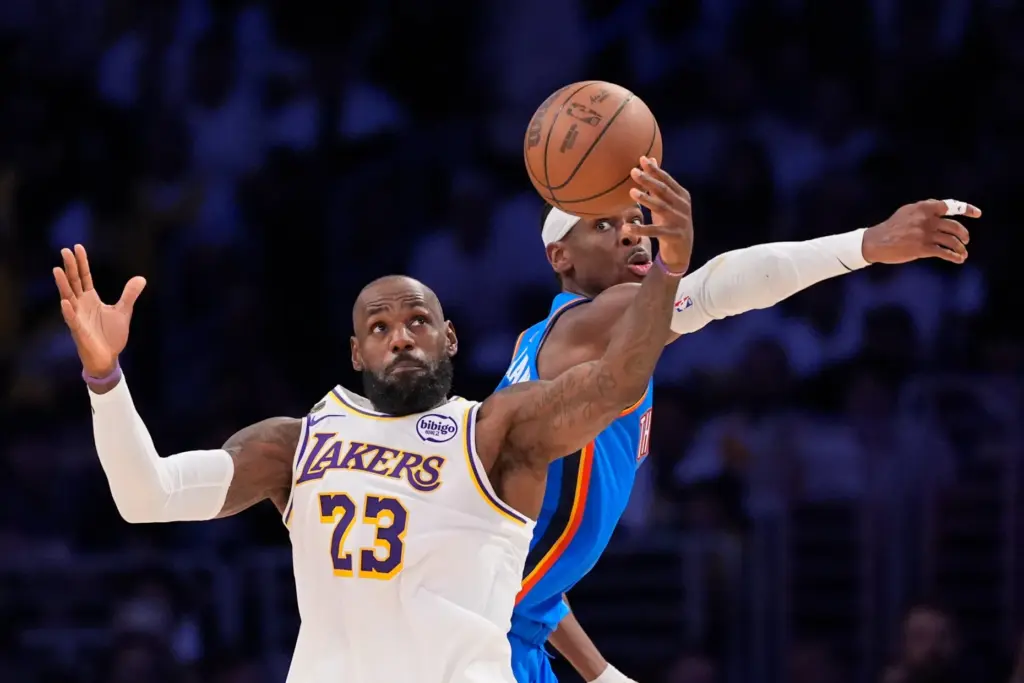 Lakers star LeBron James, left, catches a pass from a...