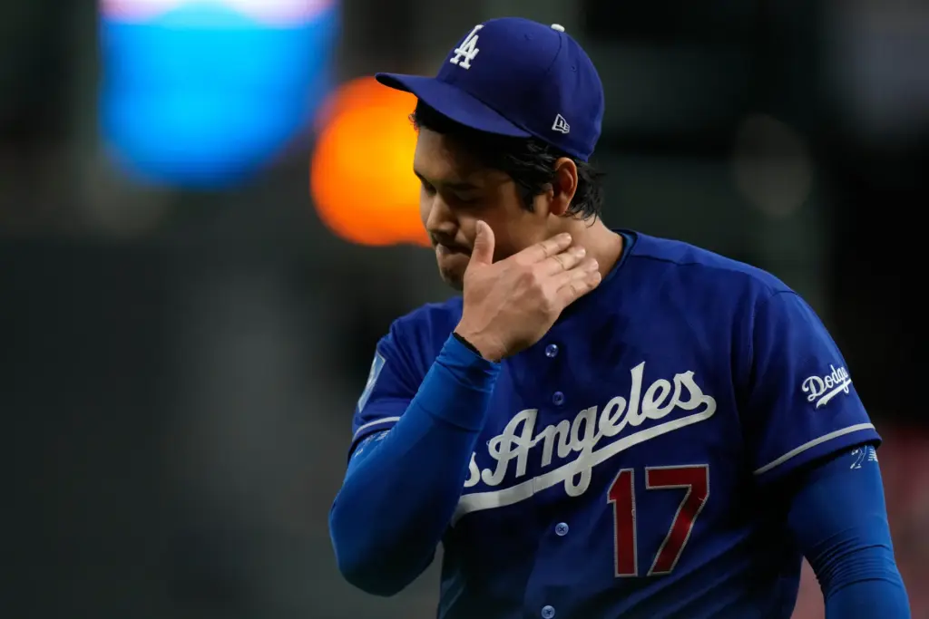 Dodgers starting pitcher Shohei Ohtani wipes away some sweat during...