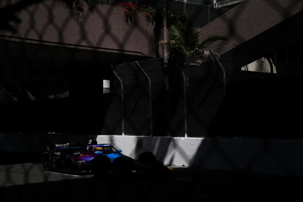 Indycar driver Marcus Ericsson hustles down the back stretch in...