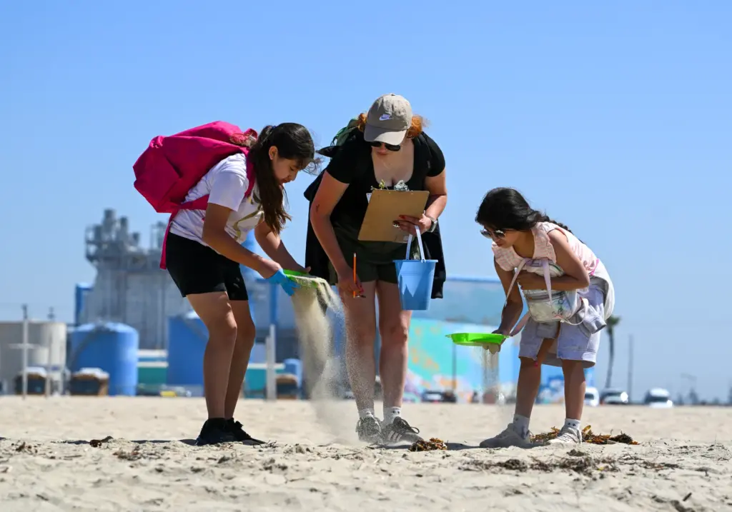 Korinthya Sosa, left, Orly Luna and Amaryllis Luna sift through...