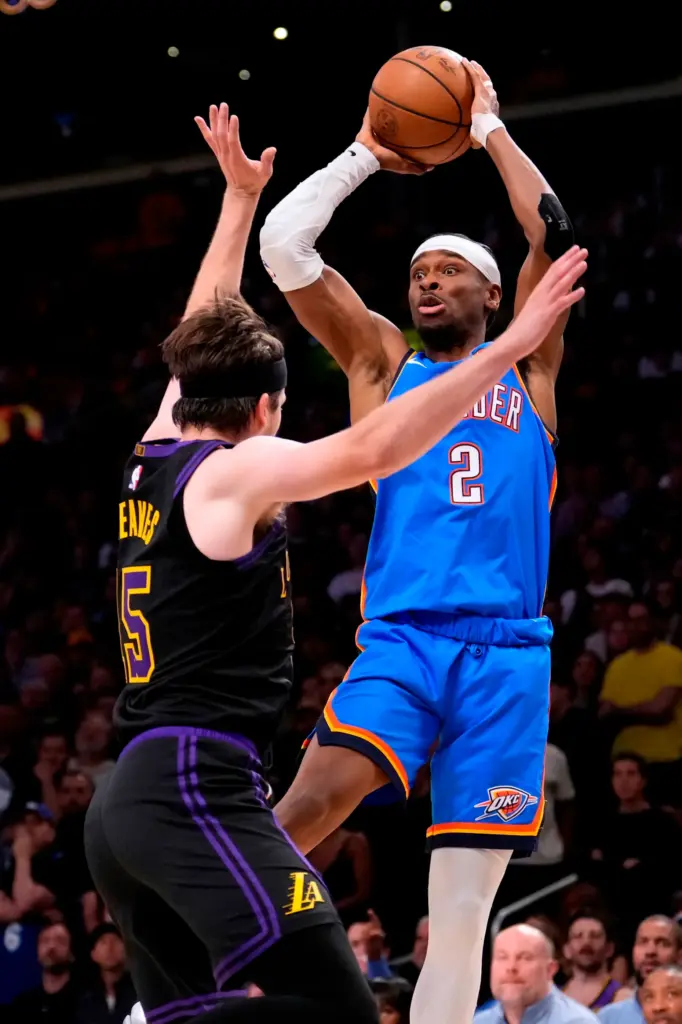 Oklahoma City Thunder guard Shai Gilgeous-Alexander, right, passes the ball...