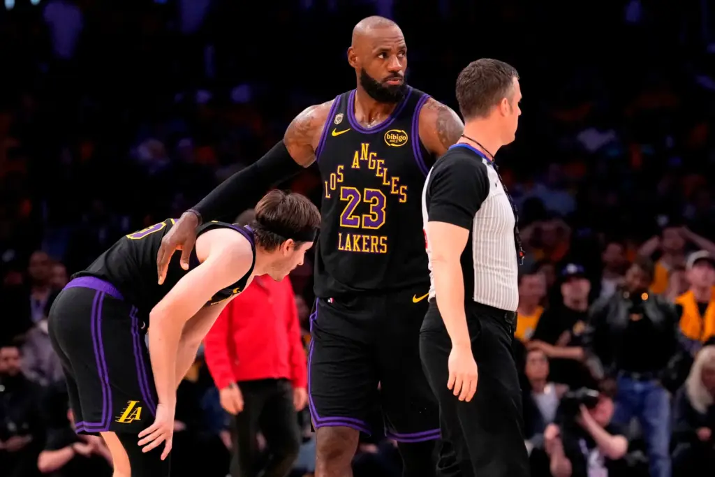 Lakers forward LeBron James, right, pats guard Austin Reaves after...