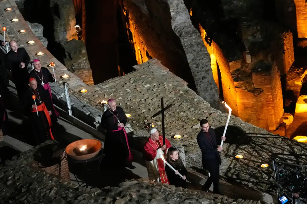 Pope Leo XIV carries a lightweight, 5-foot wooden cross during the Via Crucis.