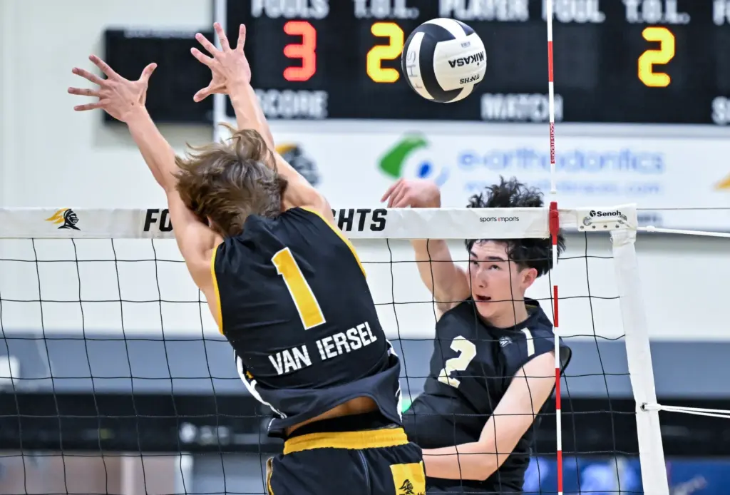 Servite opposite hitter Brandon Bartholomew hits the ball down the...