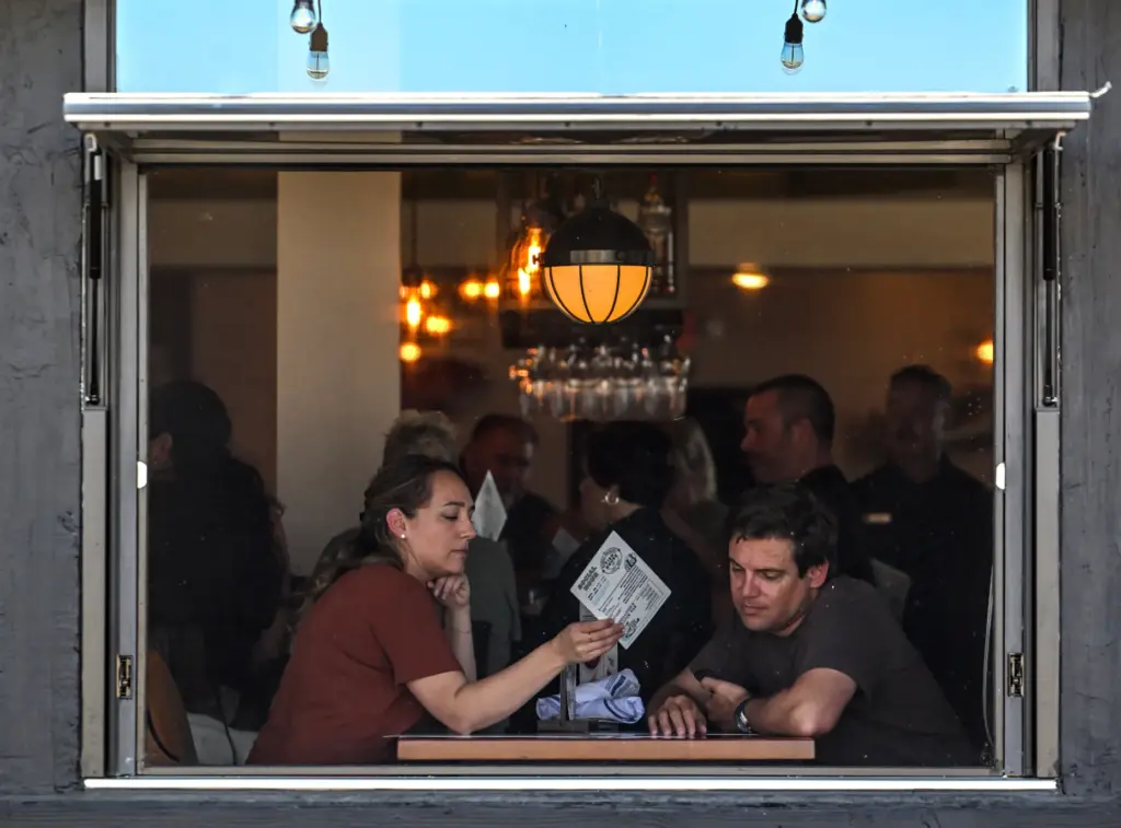 Corey Walker and Courtney Wann sit by an open window...