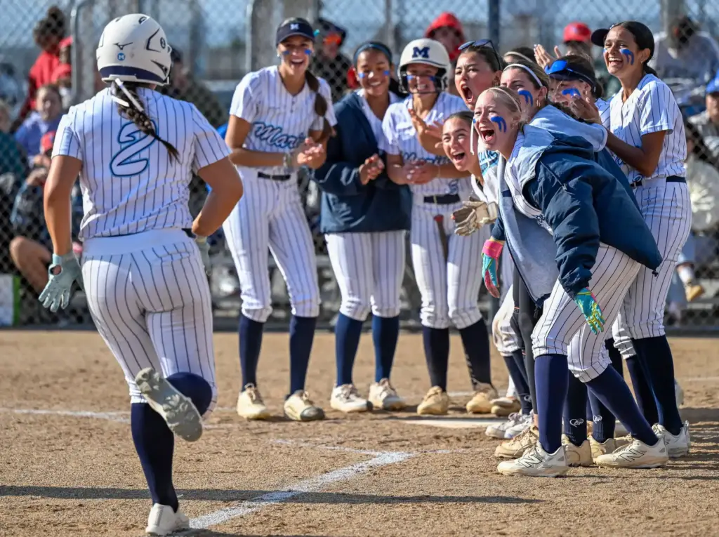Marina players celebrate as they welcome back to home plate...