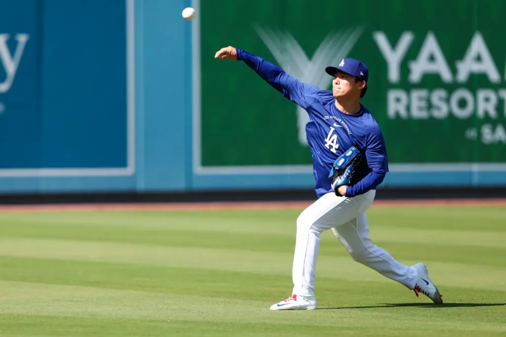 Dodgers pitcher Yoshinobu Yamamoto works out in the outfield before...