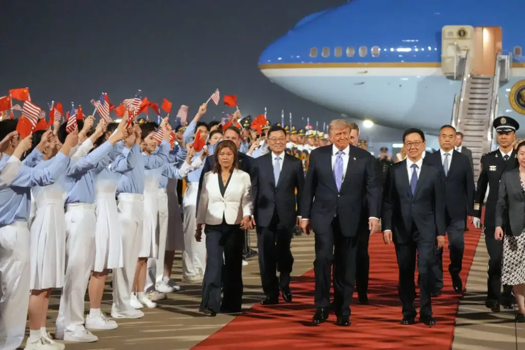 President Donald Trump walks with China’s Vice President Han Zheng...