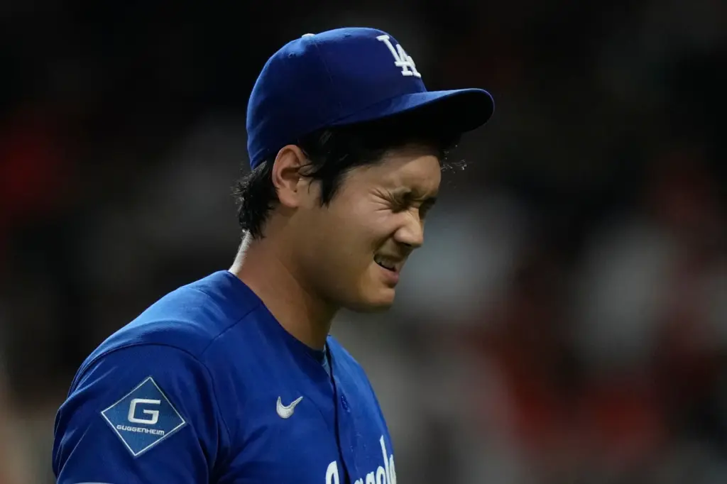 Dodgers starting pitcher Shohei Ohtani walks back to the dugout...