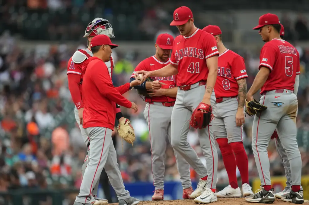 Angels manager Kurt Suzuki, left, takes the ball from starting...