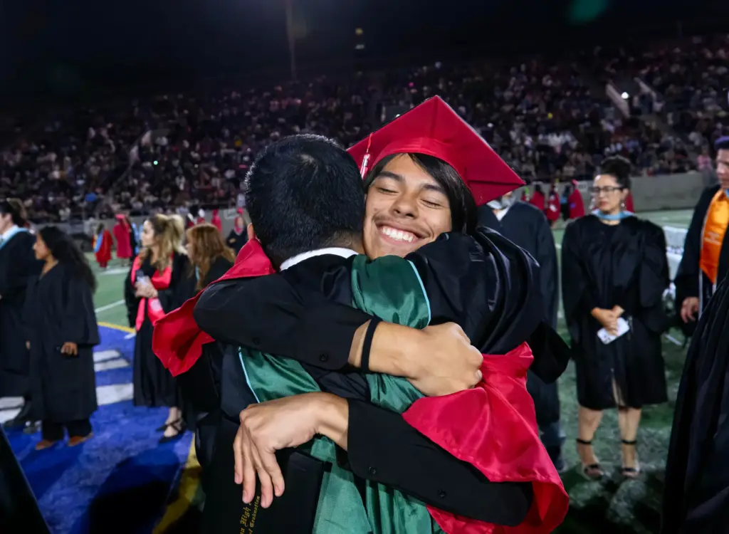 A Santa Ana High School graduate hugs one of his...