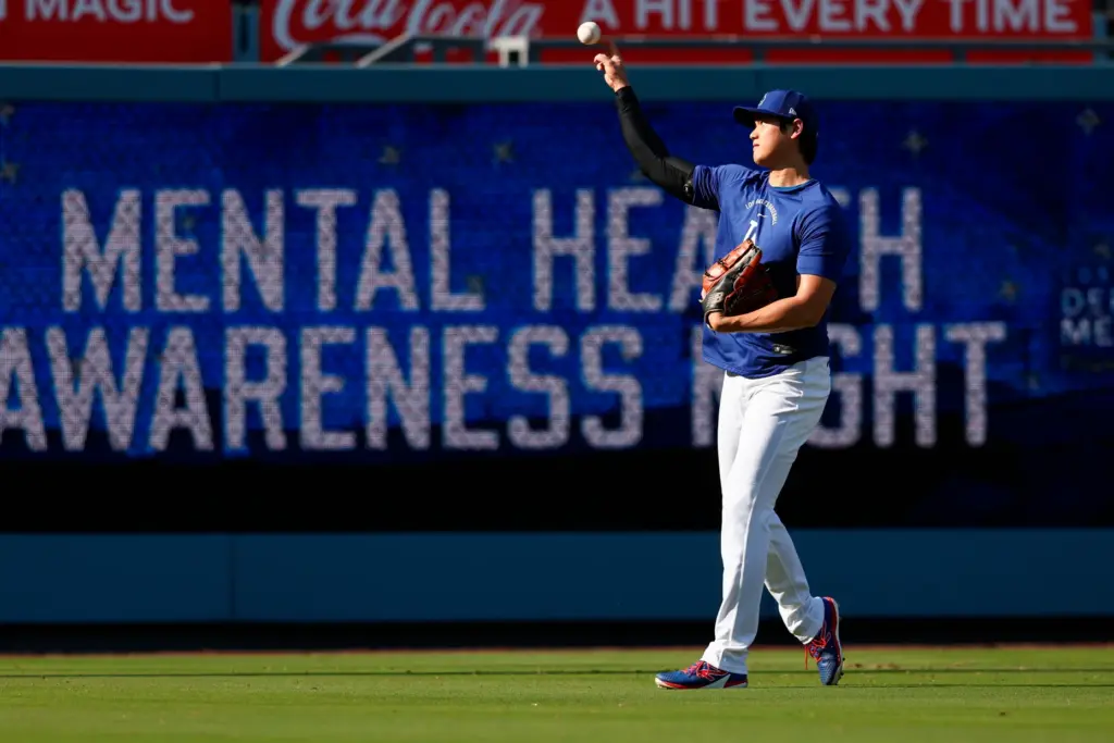 Dodgers two-way star Shohei Ohtani warms up in the outfield...