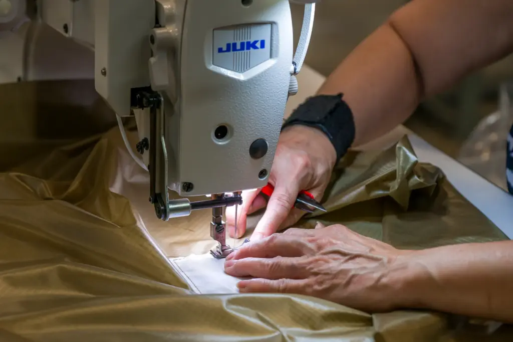Hang Vuong, a sewing machine operator, works on a Juki...