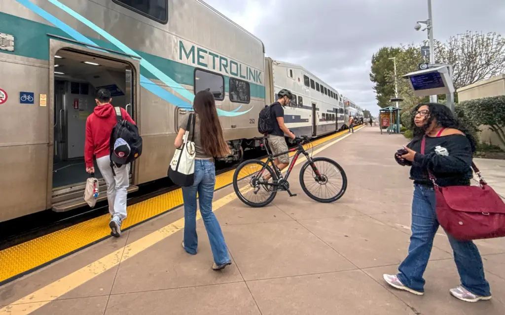 People board a northbound Metrolink train in Irvine, CA, on...