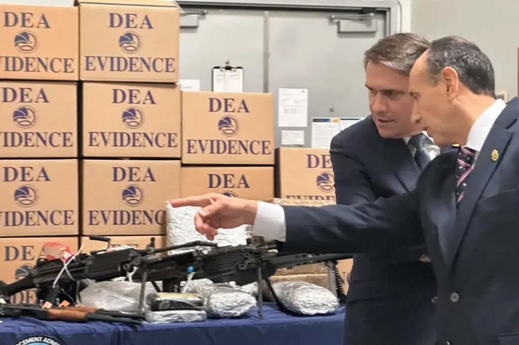 Acting Attorney General Todd Blanche looks at weapons and drugs seized by federal officers.